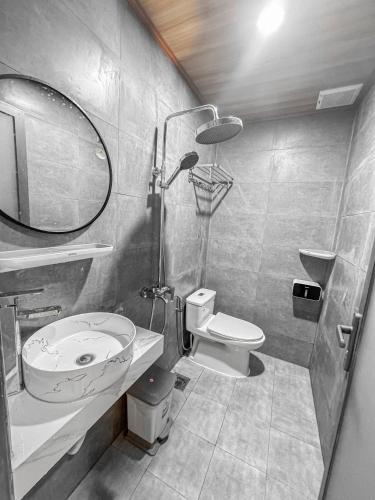 a bathroom with a sink and a toilet and a mirror at Vile Villa Homestay View Biển 01 Đảo Phú Quý in Cu Lao Thu