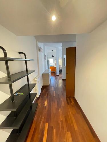 a living room with a wooden floor and a shelf at Le Palme in Lido di Ostia