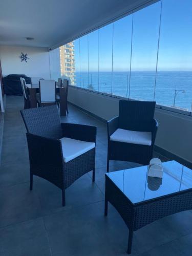 un balcón con sillas y mesas en un crucero en Departamentos Mednav Montemar & Spa, en Concón