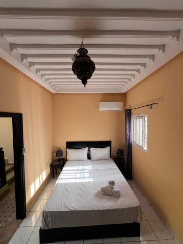 a bedroom with a bed and a chandelier at Riad Paolo Piscine Palmeraie in Marrakech