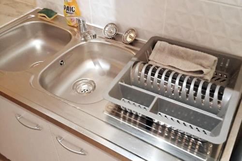 um lavatório com um suporte para secar pratos ao lado em Discount Gite confort Sortie Besançon Texas T3 em Chevigney-sur-lʼOgnon