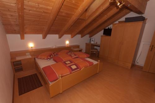 a large bed in a room with wooden ceilings at Haus Sabine in Laion