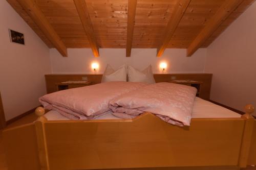 a bed with a pink comforter on top of it at Haus Sabine in Laion