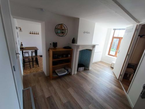 a living room with a wooden floor and a table at Au Nid Douillet in Saint-Jans-Cappel
