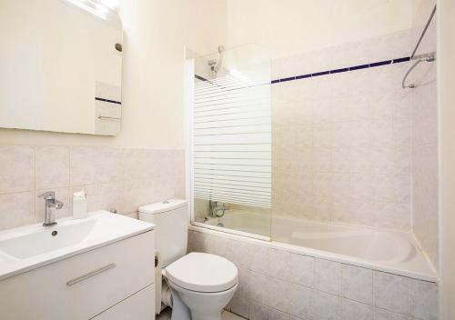 a bathroom with a toilet and a tub and a sink at Place de l'Etoile, Wagram in Paris