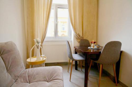 a living room with a table and chairs and a window at Family Apartment MZ27 in Vienna