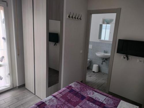 - une chambre avec un miroir, un lit et un lavabo dans l'établissement Il Grillo Di Firenze B&B, à Florence