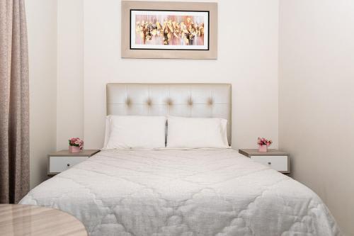 um quarto branco com uma cama com lençóis brancos em Las Palmeras Hospedaje & Restaurante em Nuevo Imperial
