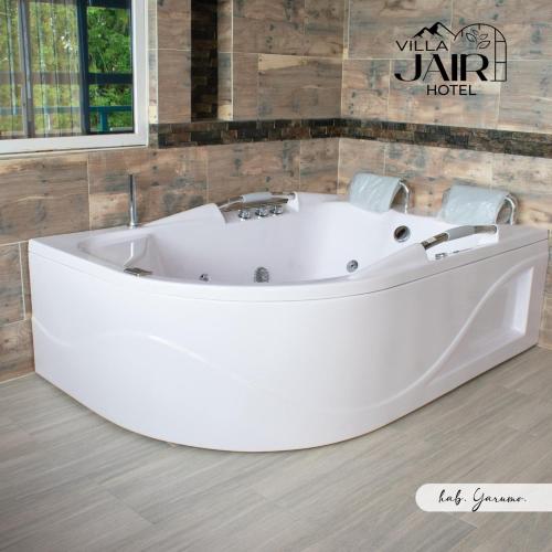 a large white tub in a bathroom with a wall at Villa Jair Hotel in Filandia