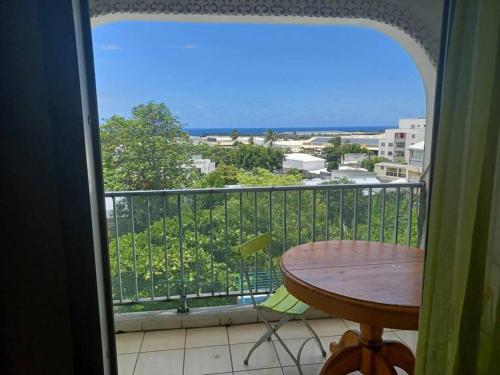 un balcon avec une table et une vue sur l'océan dans l'établissement Appartement spacieux, à Sainte-Clotilde