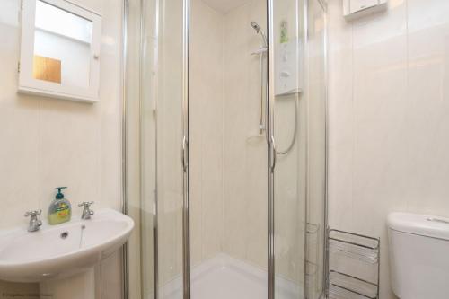 een badkamer met een douche, een wastafel en een toilet bij Chalet Twentynine in Deal