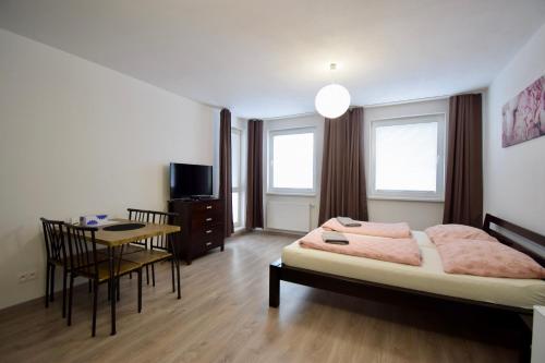 - une chambre avec un lit, une table et des chaises dans l'établissement Apartmán Zlatovská 22B, à Trenčín