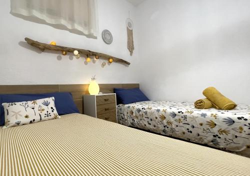 - 2 lits dans une chambre avec des draps bleus et jaunes dans l'établissement Casa Paqueldo, à Amposta