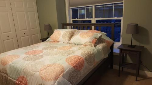 uma cama num quarto com uma janela e uma cama sidx sidx em Modern and Pristine Condo -By the GT Commons em Traverse City