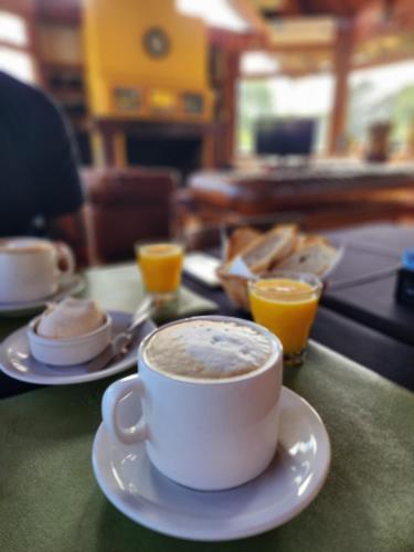 a cup of coffee on a table with plates of food at Estancia Laguna Vitel in Chascomús
