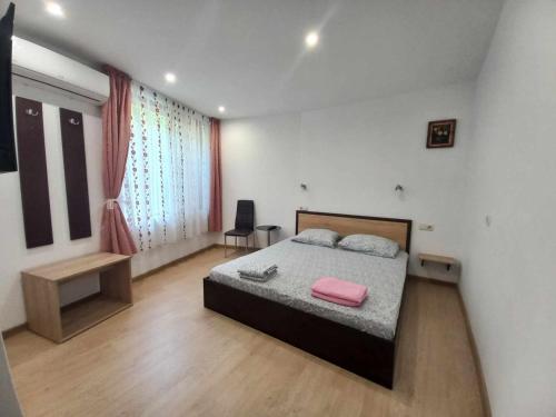 um quarto com uma cama com uma almofada cor-de-rosa em Стаи за гости Калина em Yambol
