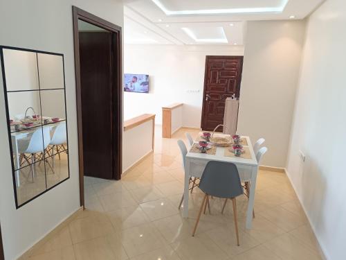 Cozy sunny apartment في ساليه: غرفة طعام مع طاولة بيضاء وكراسي