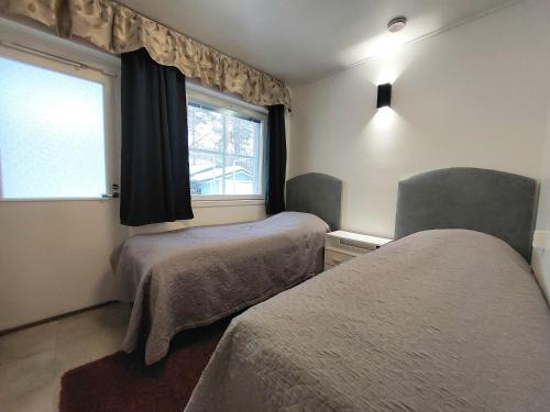 a small bedroom with two beds and a window at Paritalohuoneisto, semi-detached house in Hyvinkää