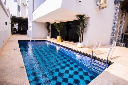 uma piscina num edifício com piso em azulejo em BON Hotel Nest Garki II Abuja em Abuja