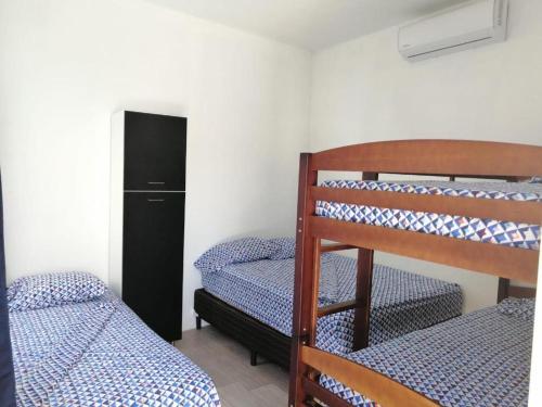 a room with two bunk beds and a refrigerator at Ola Azul Monterrico, apartamento de playa completamente equipado y con piscina privada. in Monterrico