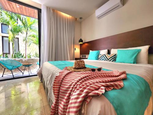 Un dormitorio con una cama con una manta. en Meliora by Bunik en Playa del Carmen