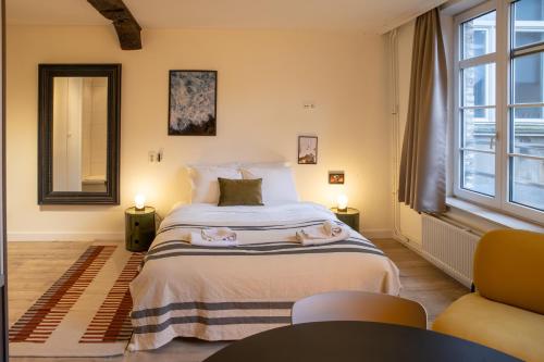 een slaapkamer met een bed met twee handdoeken erop bij Smartflats - L'Orangerie I Maastricht in Maastricht