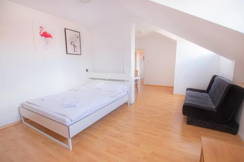 a white bedroom with a bed and a chair at Podwale str Large flat in the heart of Old Town in Warsaw