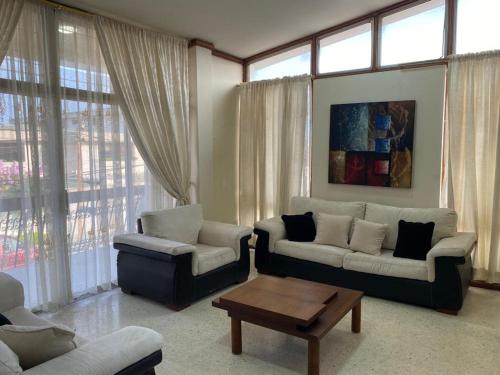 Sala de estar con 2 sofás y mesa de centro en Casa Particular, en Guayaquil