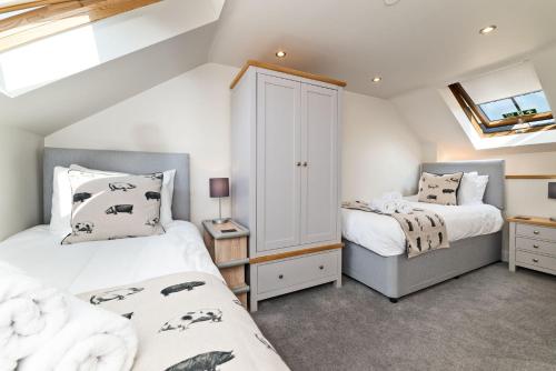 1 dormitorio con 2 camas y ventana en Piggery Cottage, en Llanasa