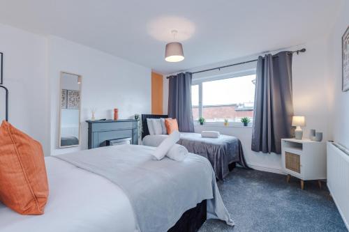1 dormitorio con 2 camas y ventana en Delighful Family House in Stalybridge Sleeps 9 with WiFi by PureStay, en Stalybridge