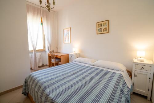 een slaapkamer met een bed, een bureau en een raam bij Elide Apartments - Comfort in Polignano a Mare
