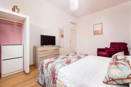 um quarto com uma cama, uma televisão e uma cadeira em Smart Home Sorrento - City center em Sorrento