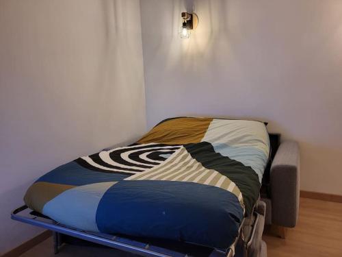 - un petit lit dans une chambre avec un cadre de lit dans l'établissement Charmant appartement T2 à Ugine, à Ugine