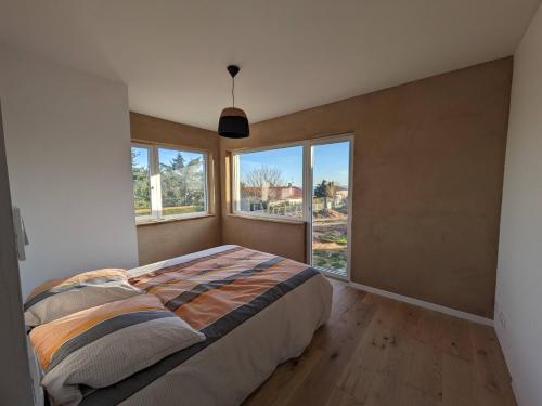 um quarto com uma cama e uma grande janela em Terre de Sienne em Saint-Clair