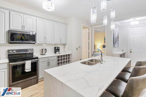 a kitchen with white cabinets and a white counter top at The Epic Tokio Vista Cay Orlando Most Stylish in Orlando