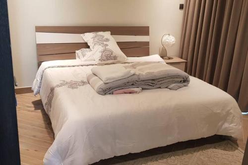 a bedroom with a white bed with a wooden headboard at New Cozy Sea View Apartment in Manama