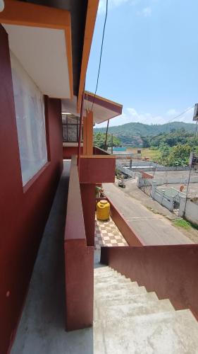 czerwony budynek z balkonem z widokiem w obiekcie S H coorg homestay w mieście Madikeri
