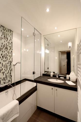 une salle de bain blanche avec un lavabo et une douche dans l'établissement Residence Bivouac, à Cannes
