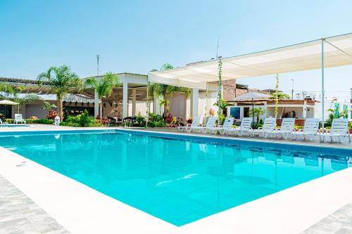 uma piscina num resort com cadeiras em Las Palmeras Hospedaje & Restaurante em Nuevo Imperial