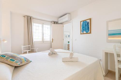 1 dormitorio blanco con 1 cama con 2 toallas en Apartamento Erizo de Mar en Felanitx