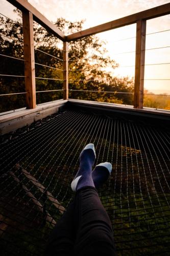 a person laying on a screened in porch with their feet up at Treedom in Prievidza