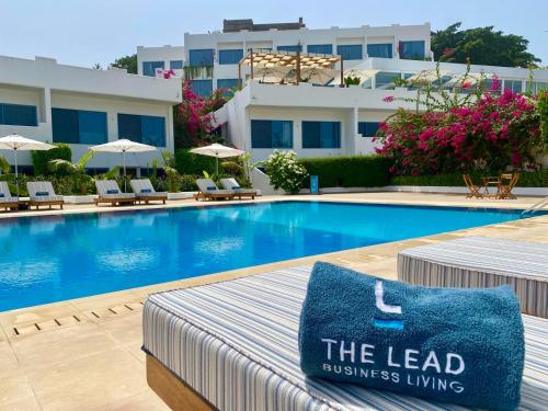 a hotel swimming pool with a blue pillow on a bed at The Lead Hotel in Freetown