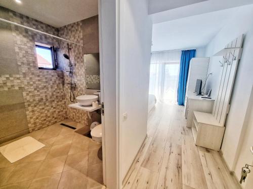 a bathroom with a shower and a toilet and a sink at Casa Cochilia - Camera Privata in Localitatea Tuzla in Tuzla
