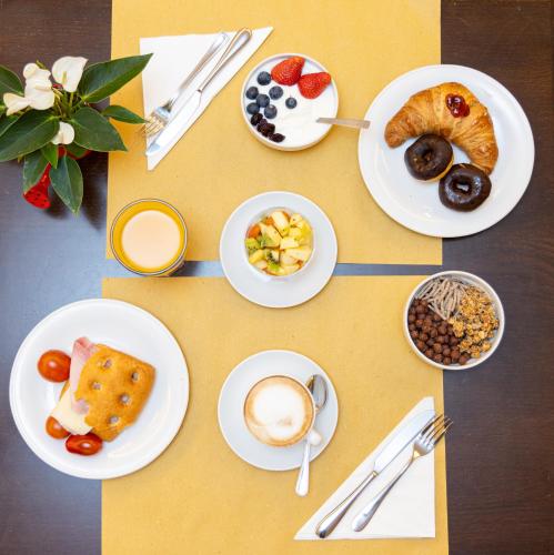 a table topped with plates of food and drinks at Best Western Hotel Crimea in Turin