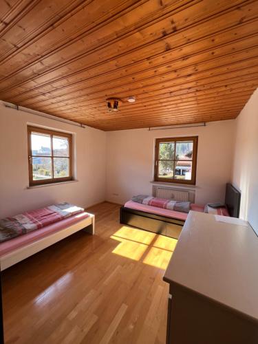 a room with two beds and a wooden ceiling at Ferienplatzl 90m2 in Peißenberg
