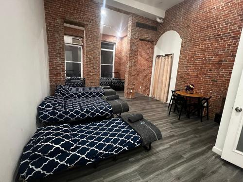 a room with four beds and a brick wall at 31 Street Broadway Hotel in New York