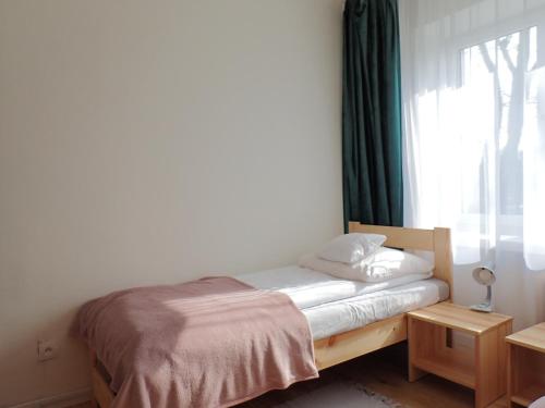 Bett in einem Zimmer mit Fenster in der Unterkunft hutApart Nowa Huta in Krakau