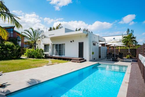 une villa avec une piscine et une maison dans l'établissement United Resort Kibougaoka, à Onna