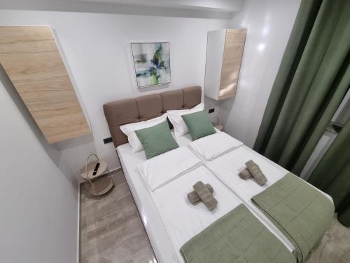 - une petite chambre avec un grand lit et des oreillers verts dans l'établissement Gracienda, à Bilice
