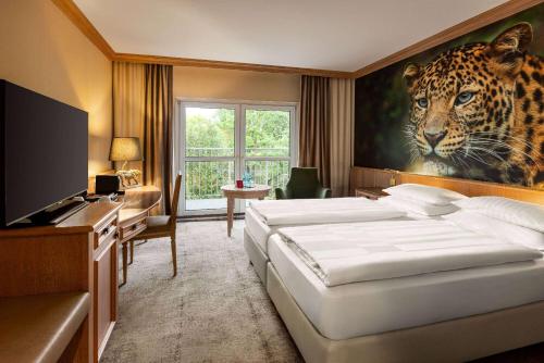a bedroom with two beds and a large painting of a leopard at Amedia Hotel & Suites Leipzig, Trademark Collection by Wyndham in Leipzig